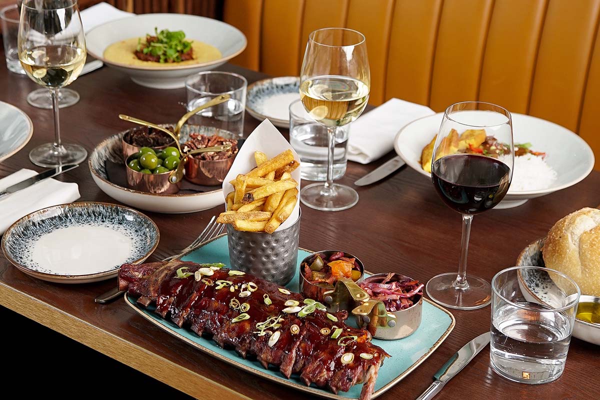 americana food on table with wine glasses - Americana Restaurant Haymarket / Piccadilly